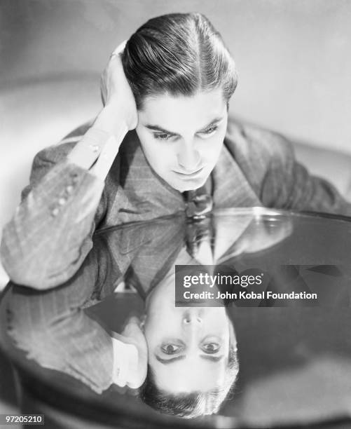 American film star Tyrone Power looking into a mirror, circa 1930.