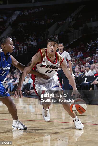 Stacey Thomas of the Portland Fire drives to the basket defended by Elaine Powell of the Orlando Miracle during the game on June 26, 2002 at the Rose...