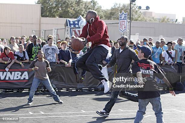 In this handout photo provided by Disney, Cincinnati Bengals wide receiver Chad Ochocinco drives to the basket as New York Jets cornerback Darrelle...