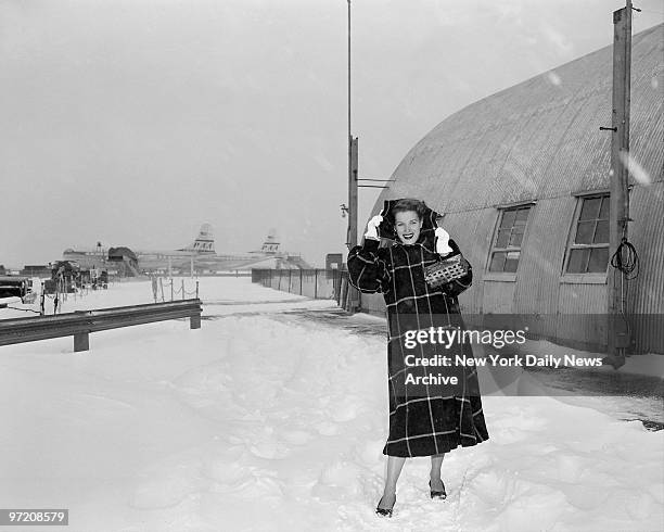 Actress Maureen O'Hara, arriving from Europe at International Airport, smiles despite freezing weather.