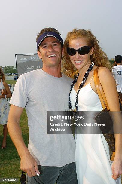 Actor Luke Perry cozies up to Michelle Barish on the fifth weekend of the annual Mercedes-Benz Polo Challenge at the Bridgehampton Polo Club in...