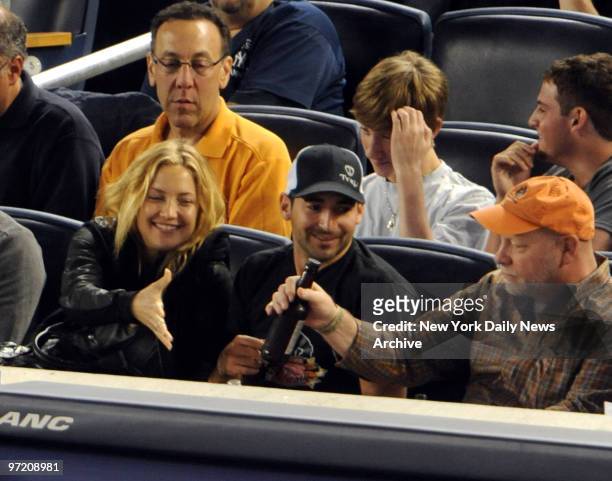 Actress Kate Hudson reaches for a beer at the Yankee game against the Tampa Bay Rays.