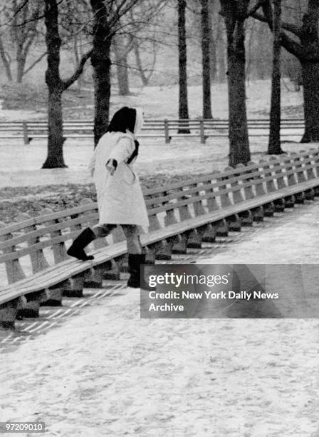 Actress Katharine Hepburn runs from Central Park bench to avoid photographer.