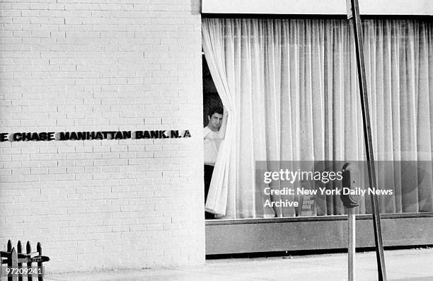 Alleged stickupman John Wojtowicz looks through the Chase Manhattan Bank window.