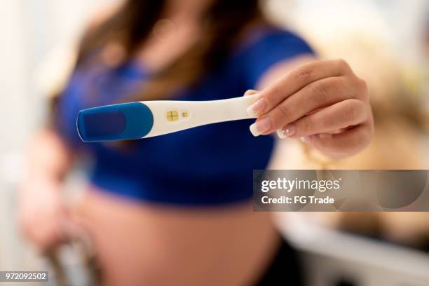 young woman showing pregnancy test - urine culture stock pictures, royalty-free photos & images