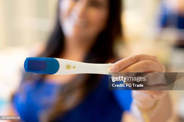 young woman showing pregnancy test - urine culture stock pictures, royalty-free photos & images