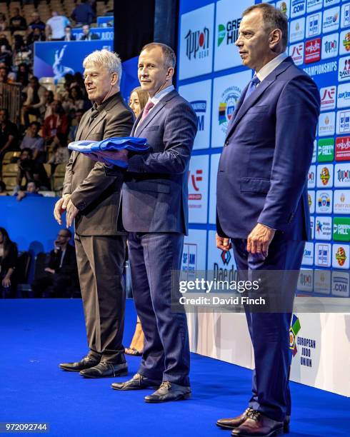 European Judo Union President, Sergey Soloveitchik, centre, briefly holds the EJU flag that he received from the Israel Judo Association President,...