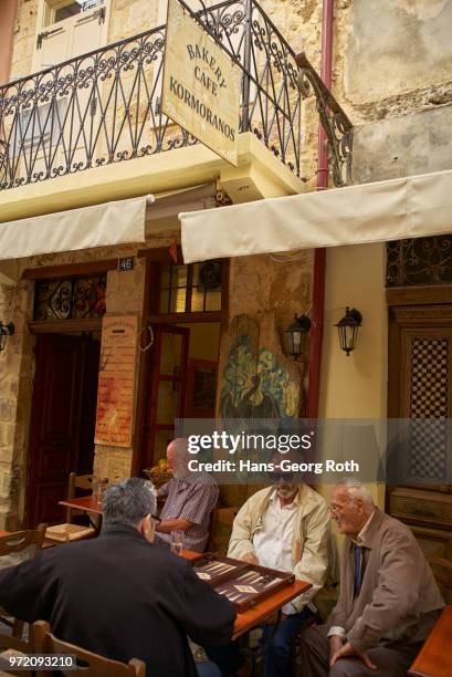 greek men play backgammon in front of the bakery kormoranos - greek ethnicity stock pictures, royalty-free photos & images