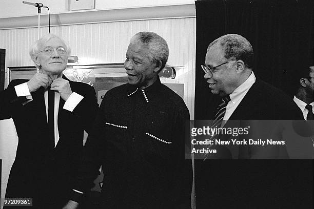 Actor Richard Harris adjusts his tie as South African President Nelson Mandela and James Earl Jones watch. The three are attending the world premiere...