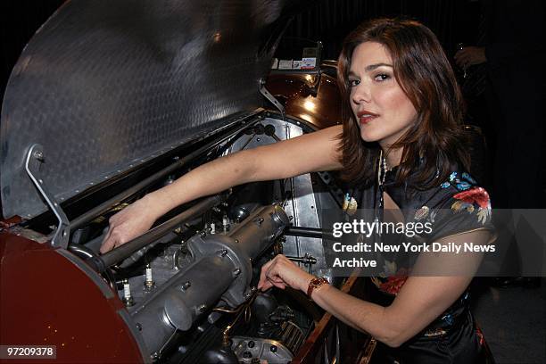 Actress Laura Harring looks to see what makes a 1935 Alfa Romeo sports car tick at the East Side House Settlement Benefit Gala Preview of the New...