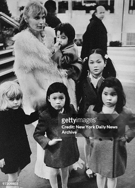 Actress Mia Farrow and five of her seven children enjoy winter sunshine. Mia holds Misha and next to Mia stands Soon Yi. In front, left to right:...