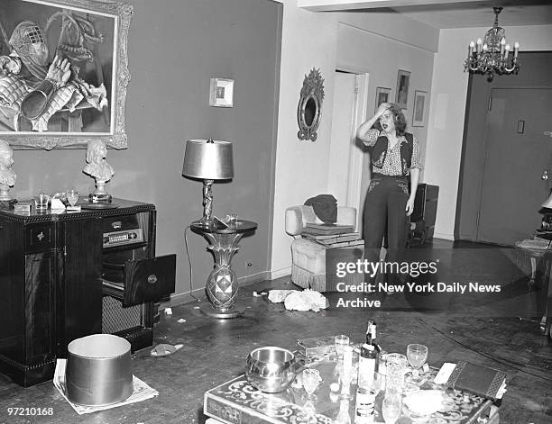 Actress Diana Barrymore registers dismay at her damaged living room, 450 E. 63rd St. Empty liquor bottles and beer cans attest to drinking bout. John...