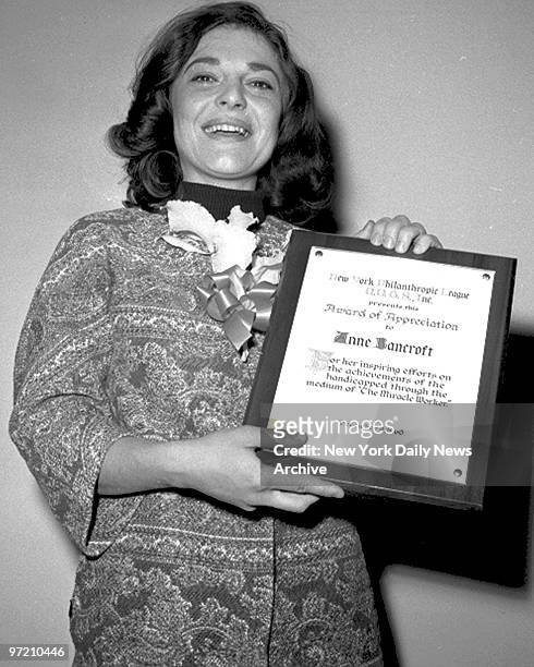 Actress Anne Bancroft holds award presented to her by the New York Philanthropic League for outstanding aid to the handicapped at the Hotel Astor....