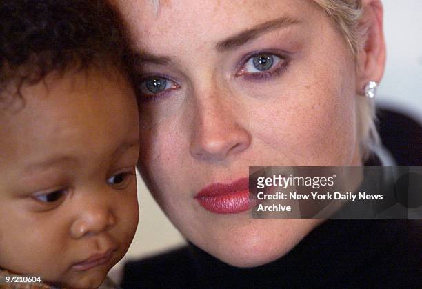 Actress Sharon Stone holds Jade Adams, 7 months, as she meets kids with AIDS at new wing of AIDS clinic at St. Luke's Roosevelt Hospital.