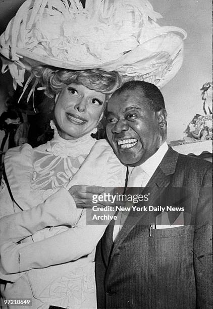 Actress Carol Channing, star of the Broadway hit "Hello Dolly" is all smiles as she greets Louis Armstrong backstage at the St. James Theatre....