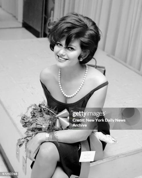 Actress Claudia Cardinale smiles at Kennedy Airport after flying in from Rome for filming of new movie. She had little time for visiting before...