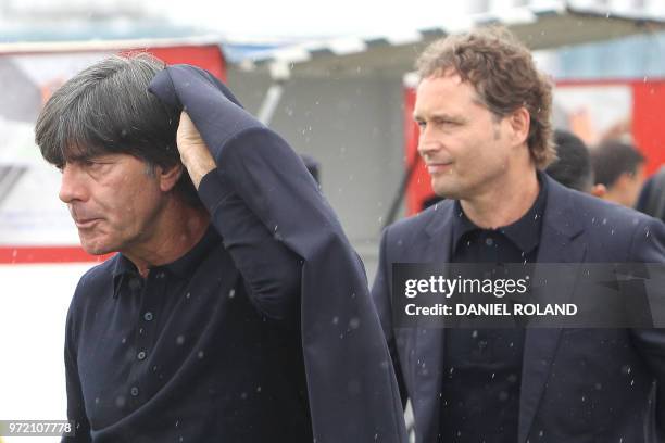 Germany's head coach Joachim Loew and assistant coach Marcus Sorg are pictured on June 12 at the airport in Frankfurt, during their departure for...