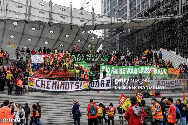 French railway workers demonstrate under the Grande Arche de la Defense on June 12, 2018 in Paris' business district of la Defense, during a 15th day...