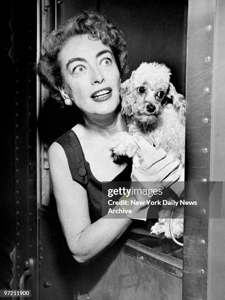 Actress Joan Crawford and her puppy arrive in Grand Central Terminal aboard the Commodore Vanderbilt to promote her new film "Autumn Leaves."
