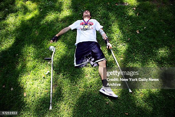 Alihana Osmanov lies down on the grass for a well-deserved rest after completing the 5-mile Hope & Possibility Run for disabled athletes in Central...