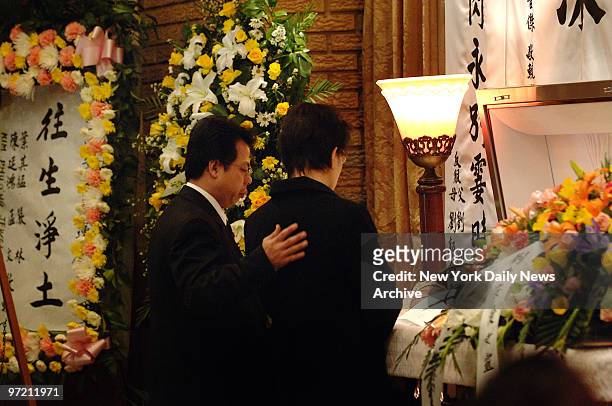 April Lao's parents, Kam and Karen Lao, say their final good-byes to their daughter at her coffin prior to a traditional Buddhist funeral service at...