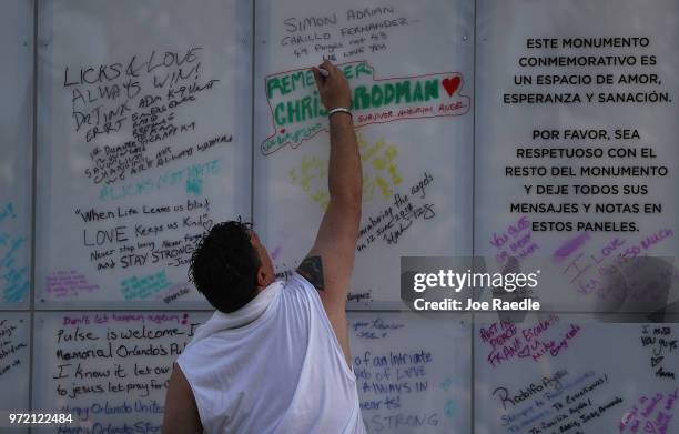 Jim McDermott writes a message on the Pulse sign as he visits the memorial to the 49 shooting victims setup at the Pulse nightclub where the...