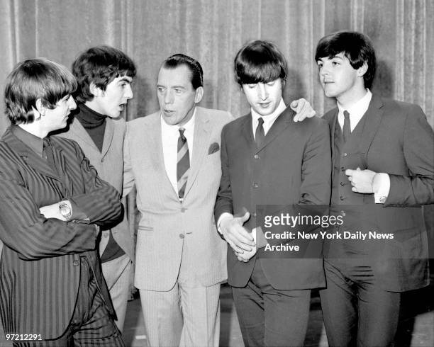 American television host Ed Sullivan talks, with the members of British rock group the Beatles, on the set of his television variety series, 'The Ed...