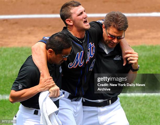 After extending making a catch at first base, New York Mets starting pitcher Jonathon Niese collapses on the mound during his first warmup after the...