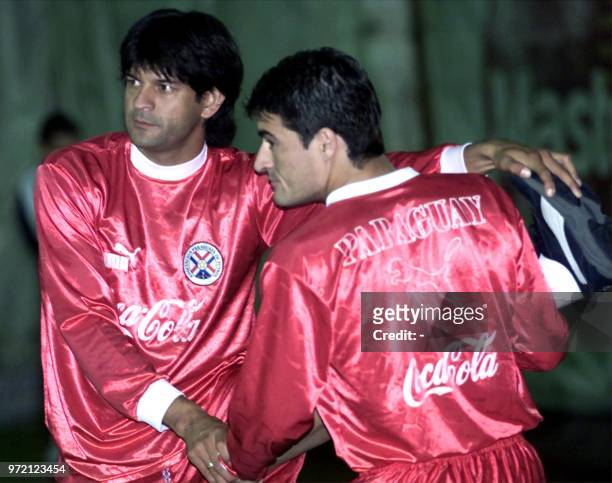 Soccer players for the Paraguayan selection Roberto Acuna and Guido Alvarenga strech during a training 25 March 2001 in Montevideo, Uruguay. Los...