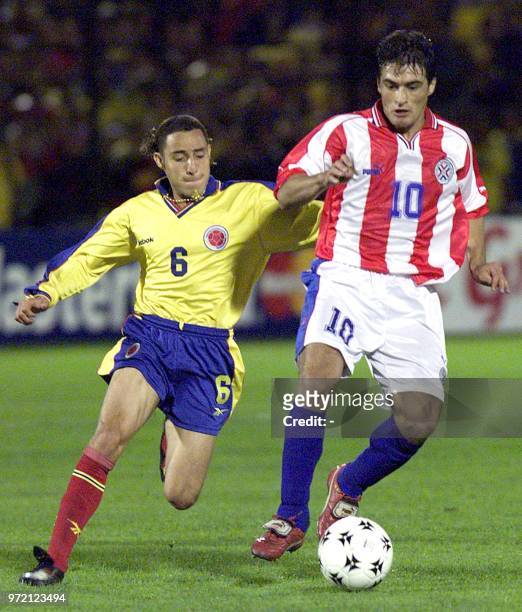 Colombia's Jorge Bolanos fights for the ball with Paragguay's Roberto Acuna 07 October during their World Cup qualification game in Bogota's Campin...