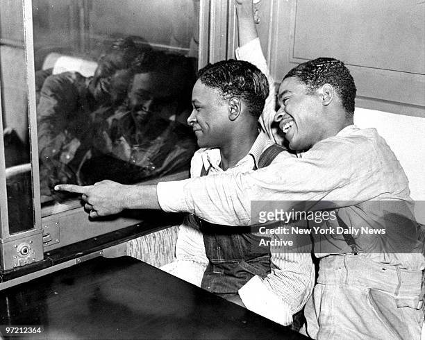 After the four Scottsboro boys were liberated, two Roy Wright and Eugene Williams are shown looking out of the train window on their arrival in New...