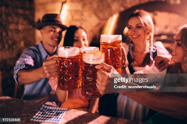 amici felici che celebrano l'oktoberfest e brindano con la birra - boccale da birra di ceramica foto e immagini stock