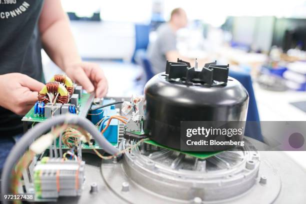 An employee works on an industrial fan at the EBM-Papst GmbH ventilation system factory in Mulfingen, Germany, on Tuesday, May 15, 2018. While...