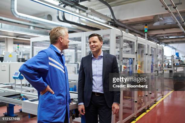 Stefan Brandl, chief executive officer of EBM-Papst GmbH, right, speaks with an employee at the company's ventilation systems factory in Mulfingen,...