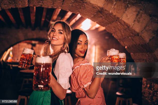 junge multi-ethnischen kellnerinnen bierausschank am bar für oktoberfest feiern - bierkrug stock-fotos und bilder