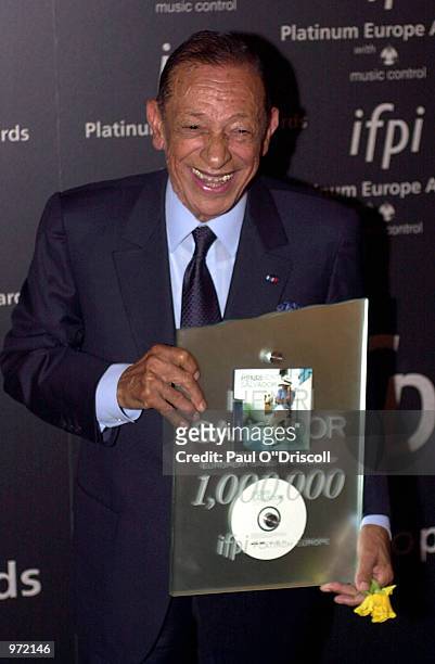 Jazz artist Henri Salvador holds an award presented to him at the International Federation of Phonographic Industries fourth annual Platinum Europe...