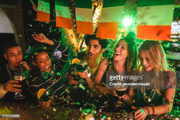 friends partying with drinks and confetti on saint patrick's day - st patricks day stock pictures, royalty-free photos & images