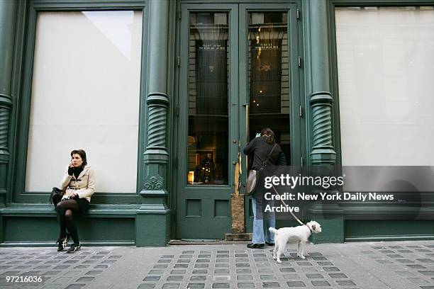 Passerby looks through the door of the Prada flagship store at 575 Broadway after a five-alarm fire ripped through the SoHo building last night. The...