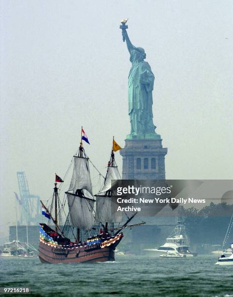 Replica of the Half Moon, the ship that took Henry Hudson up the river which now bears his name, sails past the Statue of Liberty in New York Harbor...
