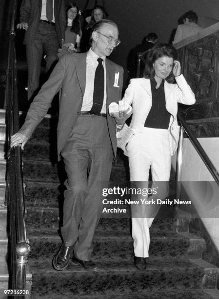 Gentleman carries the orange juice as he escorts Jacqueline Kennedy Onassis back to her seat during intermission at City Center.