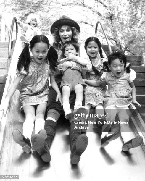 Soon Yi Previn Mia Farrow holding son Misha Lark Song and Summer enjoy ride on a slide. Mia and her children were out for a day of fun in Central...