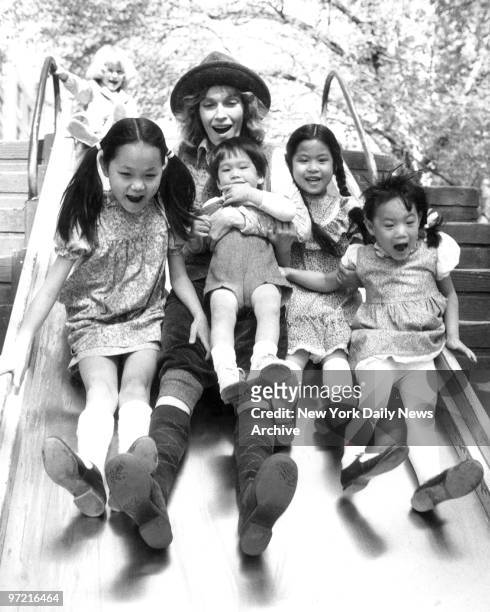 Soon Yi Previn Mia Farrow holding son Misha Lark Song and Summer enjoy ride on a slide. Mia and her children were out for a day of fun in Central...