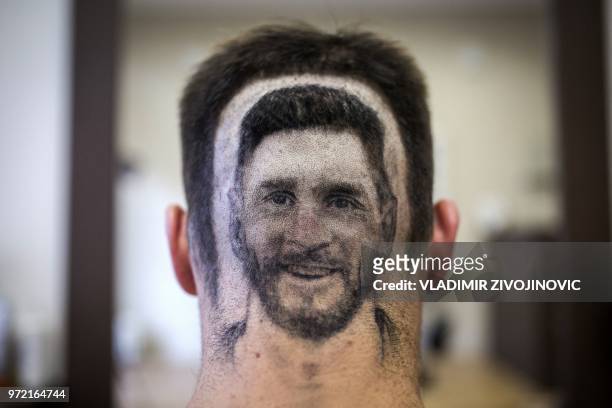 Football fan sports a hair tattoo showing the portrait of Argentinian football player Lionel Messi at a hair salon in Novi Sad, Serbia, on June 10,...