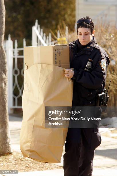 Police officer removes a bag of evidence from the home of Darryl Littlejohn in Jamaica, Queens. Littlejohn, a bouncer at the bar where Imette St....