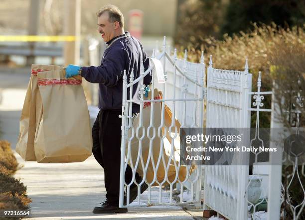 Police officer removes bags of evidence from the home of Darryl Littlejohn in Jamaica, Queens. Littlejohn, a bouncer at the bar where Imette St....