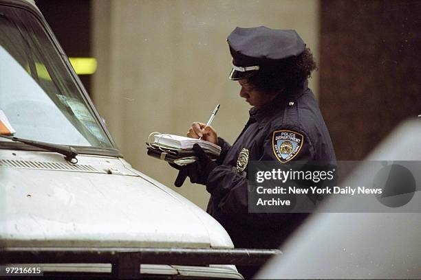 Police officer writes out a parking ticket.