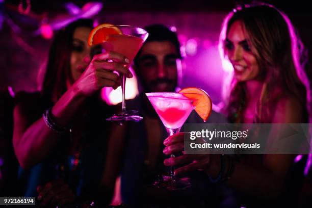 happy young friends toasting with cocktails at bar - mardi gras party stock pictures, royalty-free photos & images