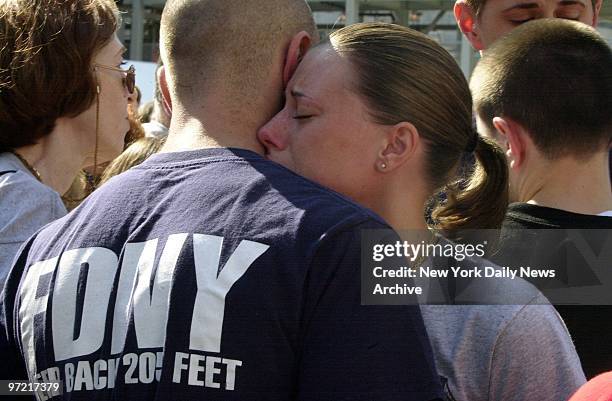 Firefighter comforts a young woman during memorial ceremonies at Ground Zero for those who died two years ago in the terrorist attacks on the World...
