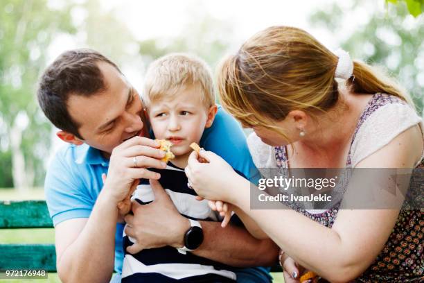 parents trying to make their son eat - ivanjekic stock pictures, royalty-free photos & images