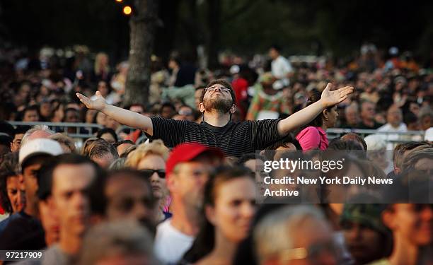 Man in the audience raises his arms to the sky on the first night of the Greater New York Billy Graham Crusade at Flushing Meadows-Corona Park in...